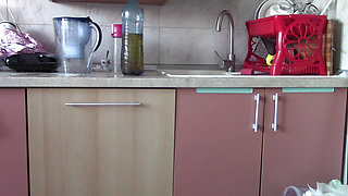 Sexy wife having fun in the kitchen with roses. Sexy naked wife preparing food in the kitchen.