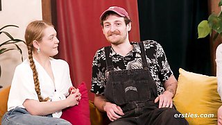 Blonde with braid and brunette talk on blue couch
