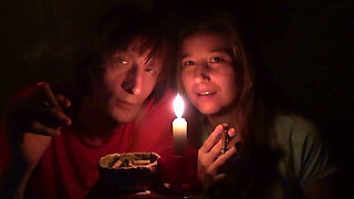 Couple Smoke Next to Candle