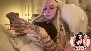 Inked Blonde Bombshell Holding Toys in Bed