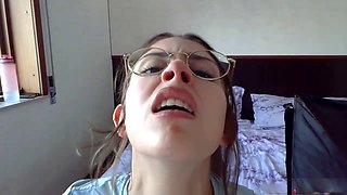 Smiley brunette teen in glasses showing off her petite body solo