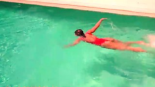 Brunette with ample mounds swims in pool