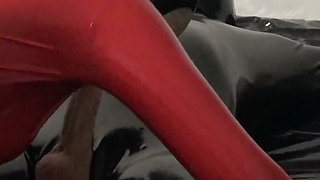 Hot MILF in a Red Latex Catsuit She Is Enjoying It with a Locked Slave.